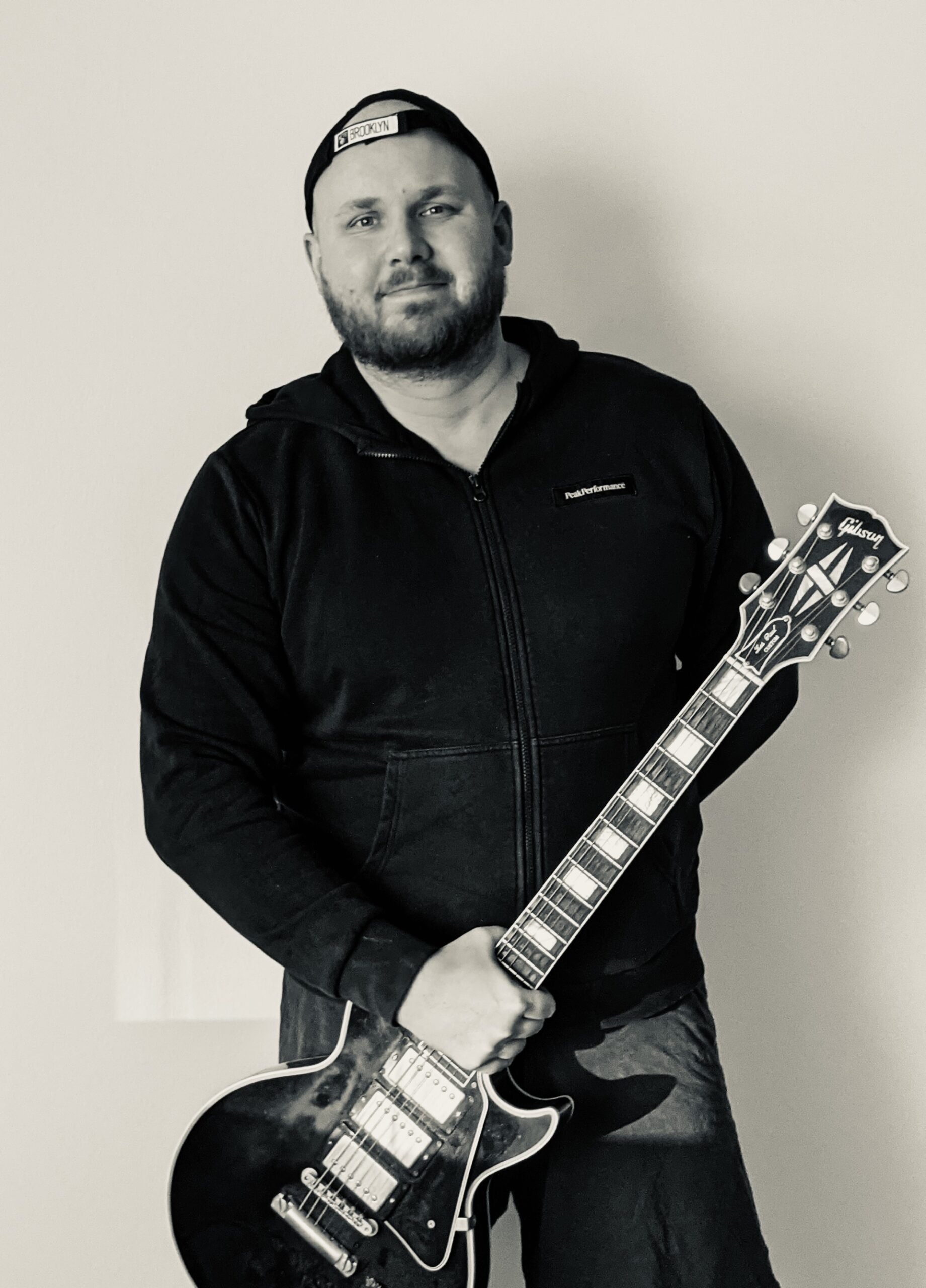 Robbie standing with a Gibson Les Paul guitar